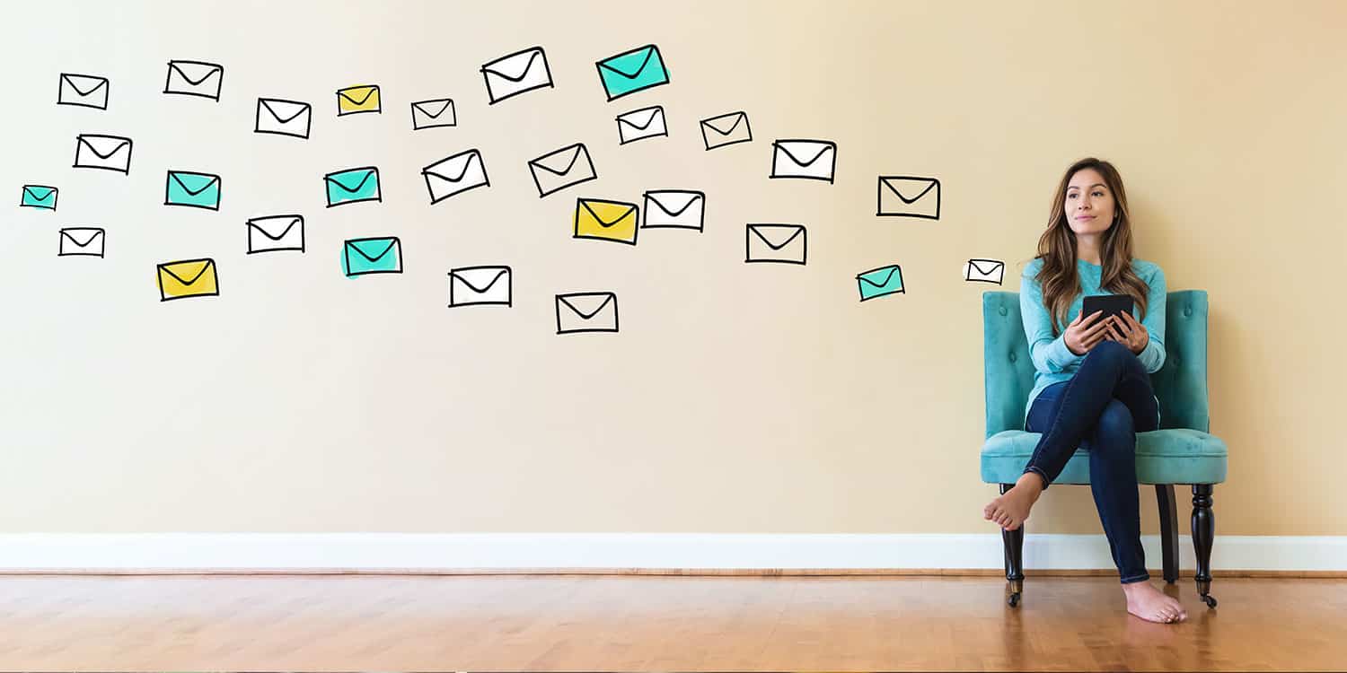 Young woman sitting on a chair with digital letters floating along the wall beside her, illustrating the concept of a digital mailroom.