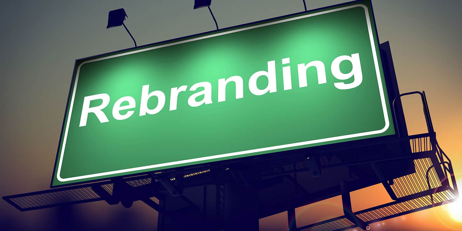 Green illuminated sign displaying the word 'Rebranding' in white letters.