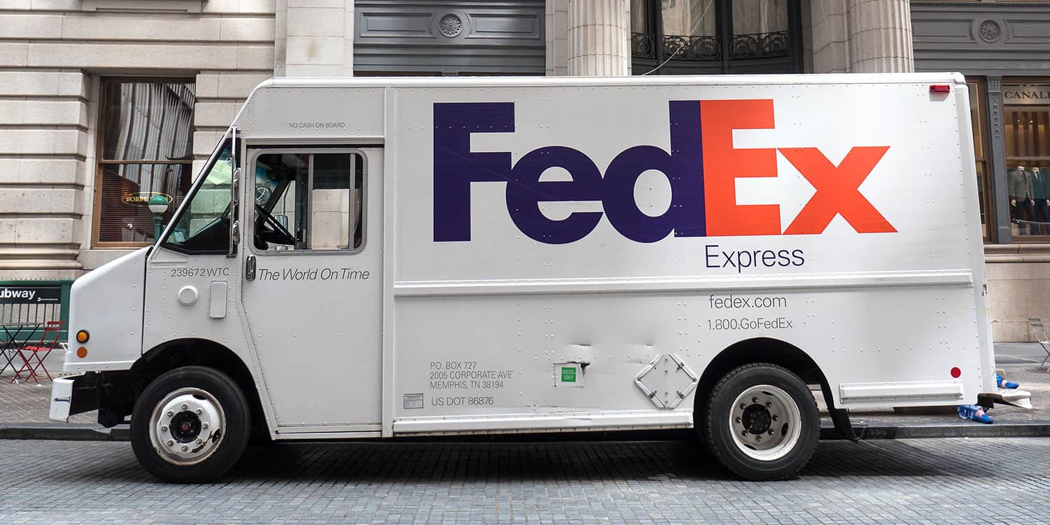 Image of a FedEx van parked outside a building, illustrating the purpose of a business address and shipping address.