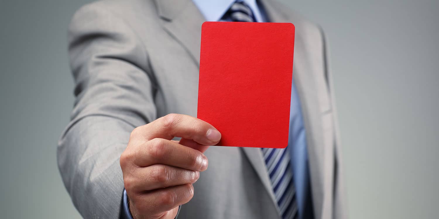 Businessman holing out a red card symbolising director disqualification.