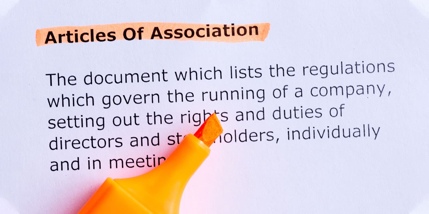 Orange highlighter on "Articles of Association" definition printed on paper.