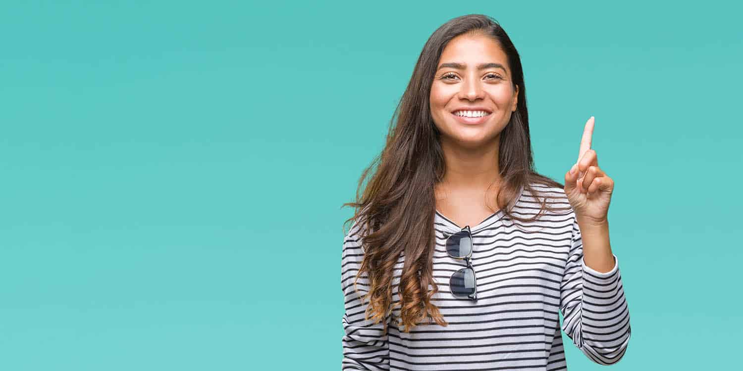 A young woman with long brown hair and striped t-shirt holding up one finger, denoting that you only need one company director in a private limited company.