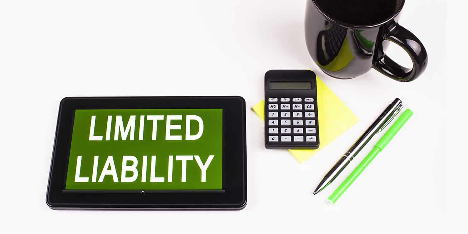 A desk containing stationary and a tablet.