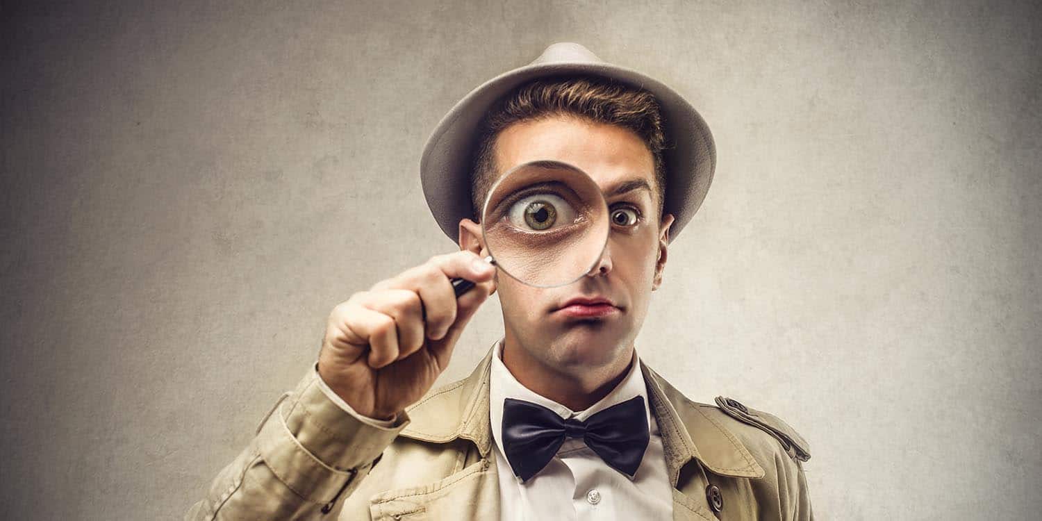 A detective holding a magnifying glass to his eye - symbolising the search for information on a company director.