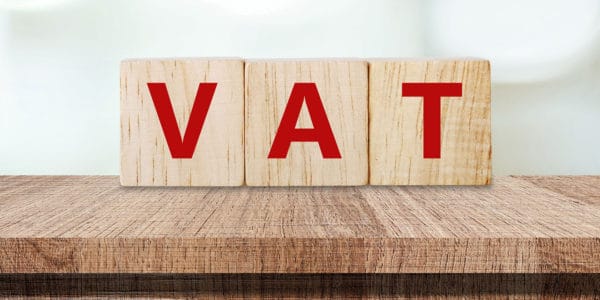 Three wooden blocks spelling out the word 'VAT'.