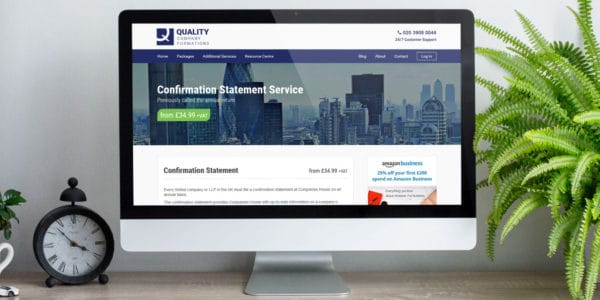Desk with a Mac monitor on top, which displays Quality Formations Confirmation Statement Service webpage.