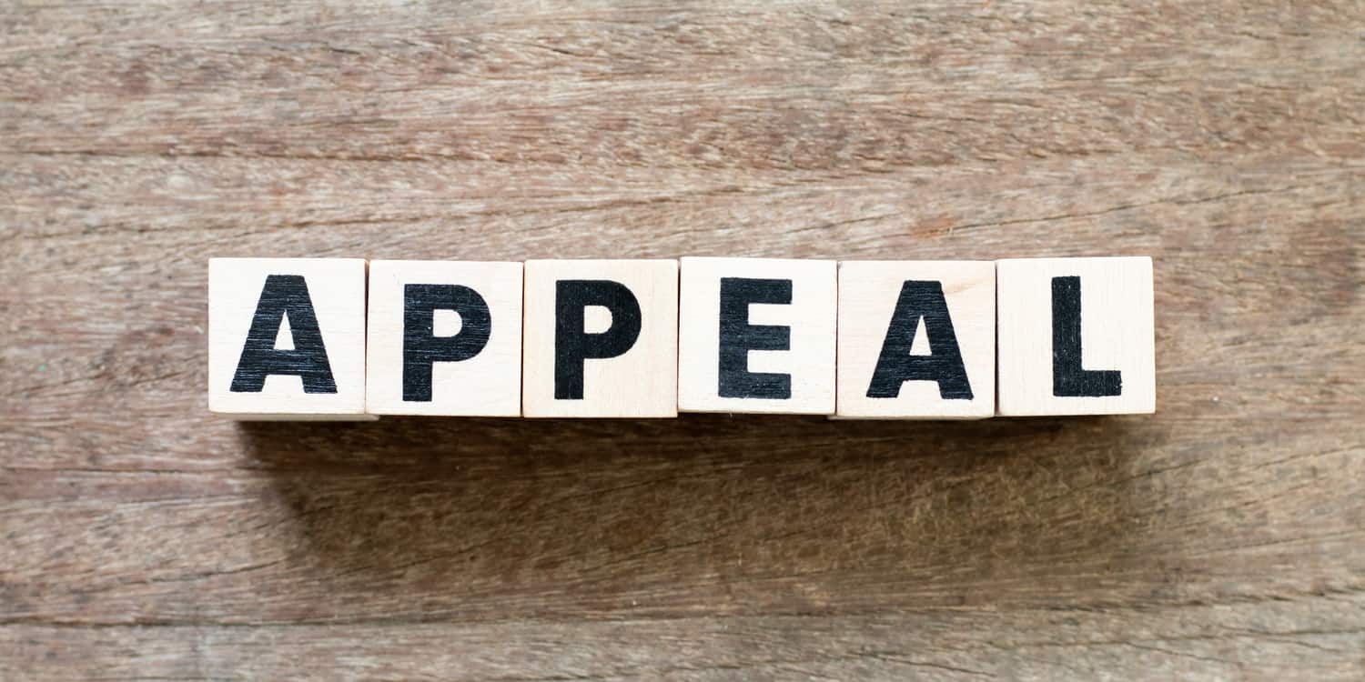 Six wooden blocks, each with a black letter, spelling the word 'APPEAL', illustrating the concept of applying to appeal a filing penalty for late accounts.