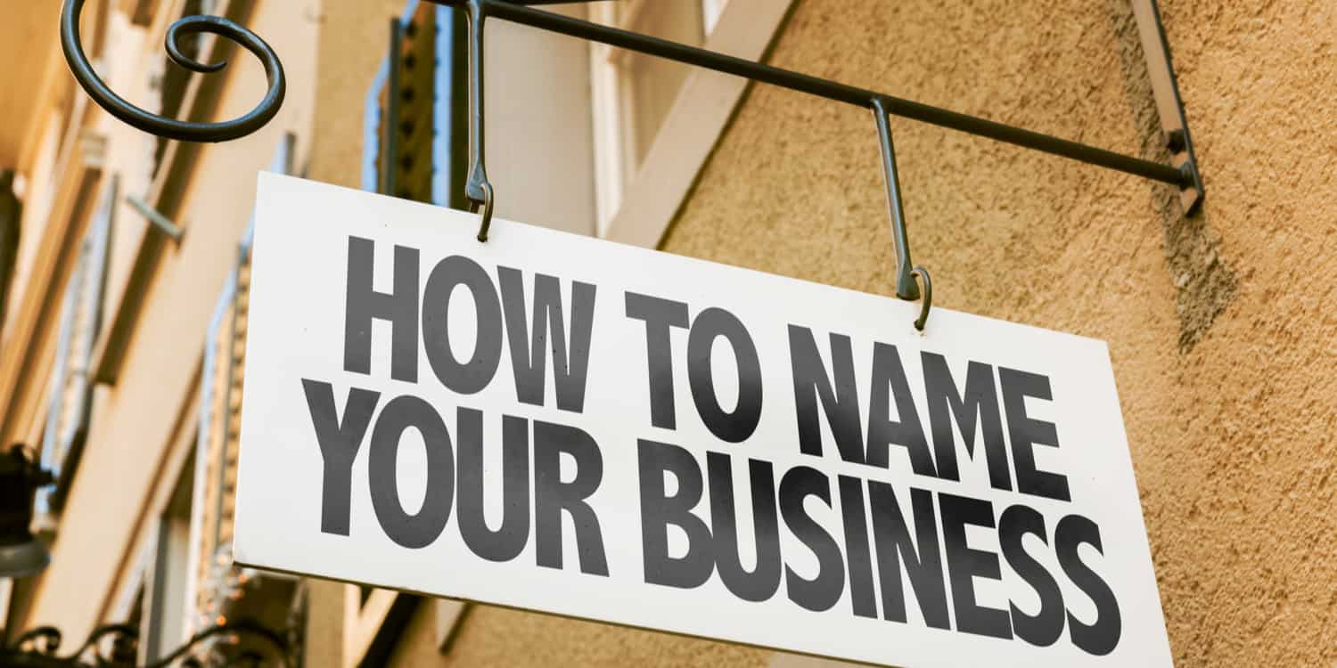 Sign hanging from wall bracket displaying the phrase 'HOW TO NAME YOUR BUSINESS'