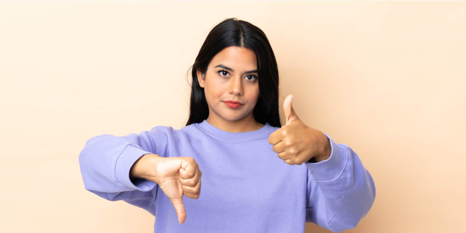 Young lady with one thumb up and the other thumb down, showing that she is undecided about whether to close a limited or make it dormant