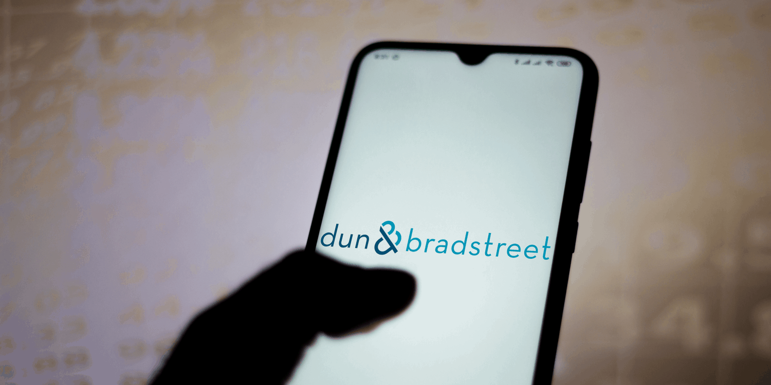 Mobile phone with business name 'dun & bradstreet' displayed on screen in blue text.