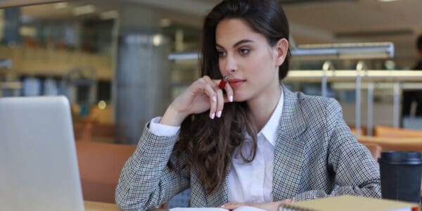 Portrait of a pretty female company secretary with laptop in office.