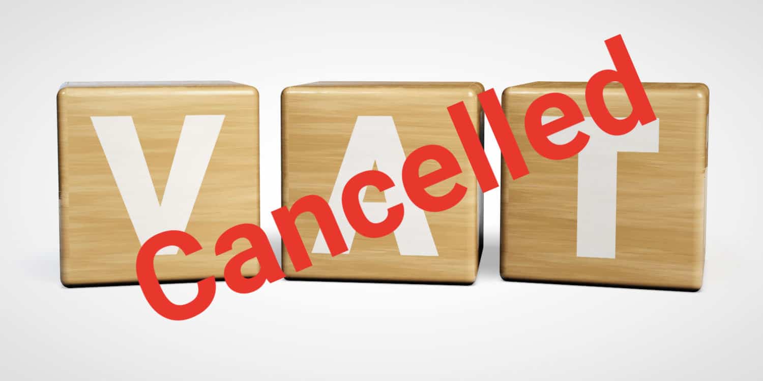 Three wooden blocks with the letters VAT displayed on them with the red headline 'Cancelled' diagonally across the image. Concept of VAT deregistration.