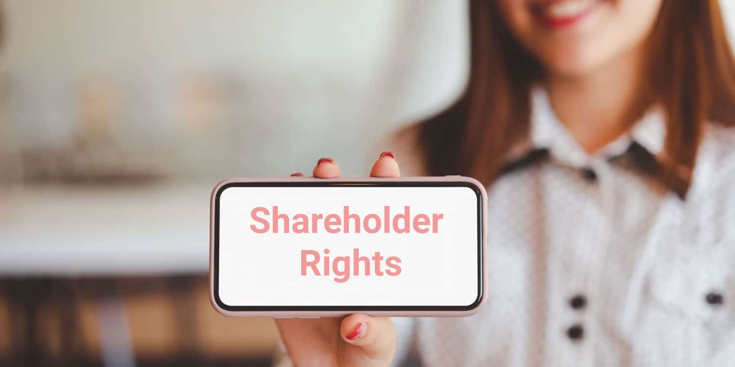 Woman's hand holding a mobile phone with the phrase 'Shareholder Rights' displayed on the screen.