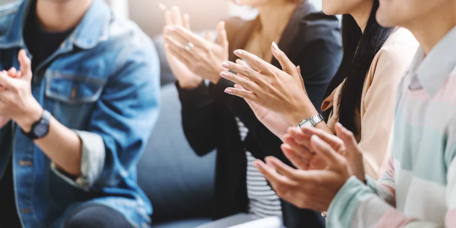 Group of directors clapping hands and congratulating a new director.