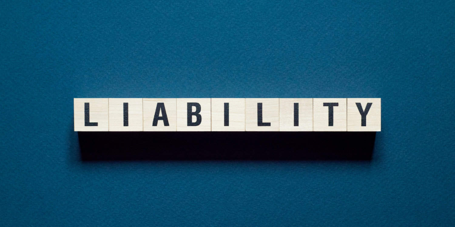 The word LIABILITY on wooden cubes with dark blue background.