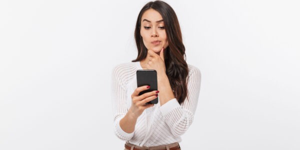 Portrait of a pensive female company director using a mobile phone and wondering when she is liable for debts.