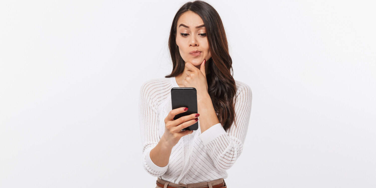 Portrait of a pensive female company director using a mobile phone and wondering when she is liable for debts.