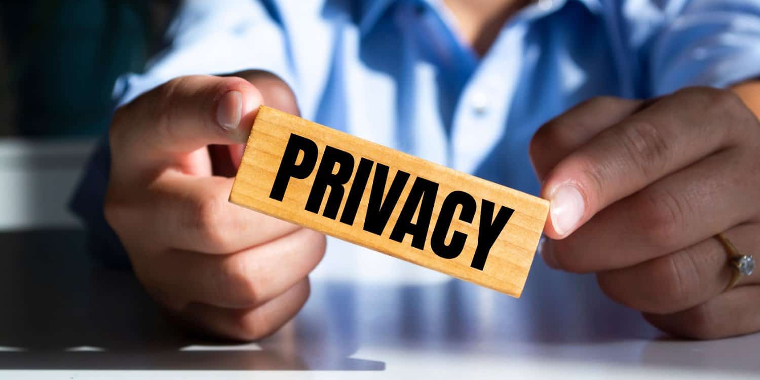 Businessman holding a wooden block with the word 'Privacy', illustrating the concept of protecting your privacy when setting up a limited company.