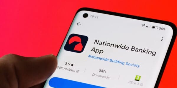 Person holding a smartphone displaying the Nationwide Banking App download screen, representing digital access to a UK bank account through mobile banking