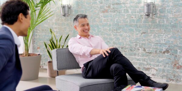 Two professionals chatting in a relaxed serviced office lounge with modern seating.