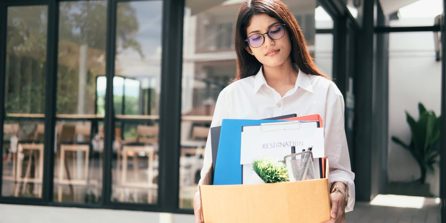Company director leaving a limited company office with official documents after resigning from her position.