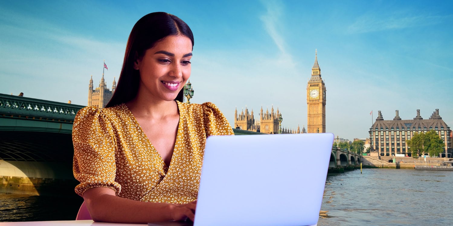 Woman smiling while working on a laptop with the Houses of Parliament and Big Ben in the background, symbolising starting an online business in the UK.