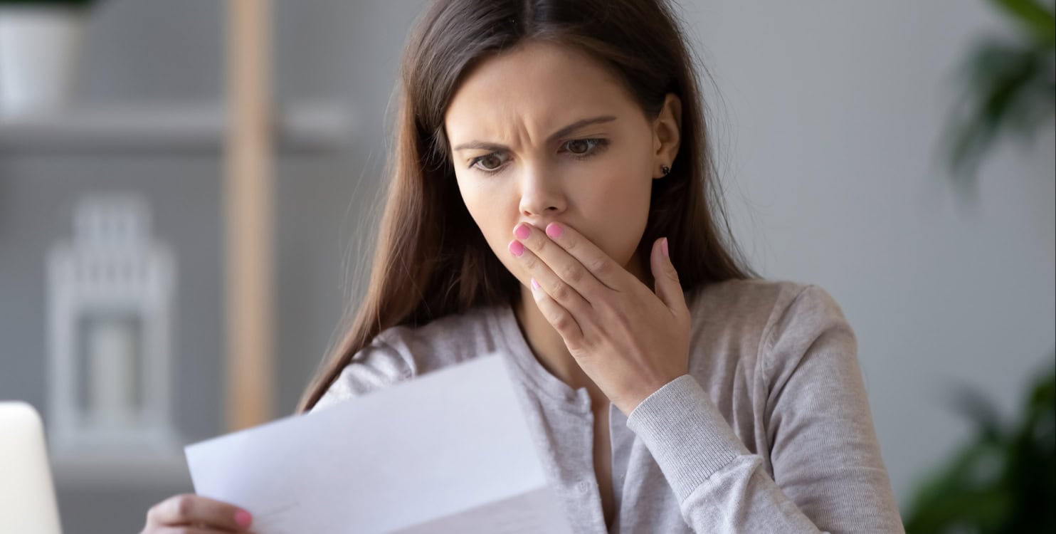 A female company director looking worried reading a letter from HMRC.
